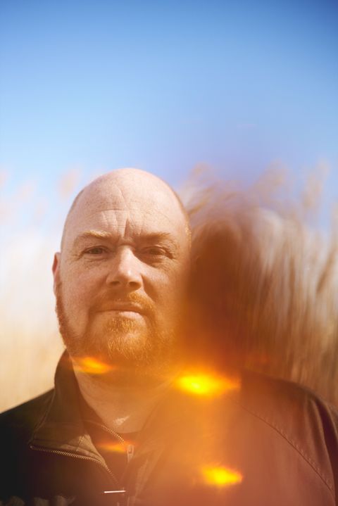 Andy Dobson, lit by an orange flare of light